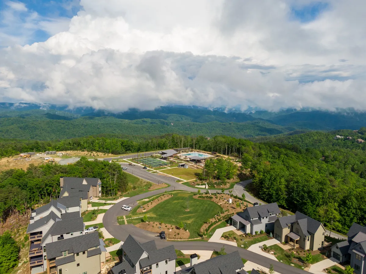 This scenic view looks out over the community's residential area, surrounded by the majestic mountain landscape and with the community center visible. The photo captures the essence of adventure and connection to the outdoors, evoking the idea of stepping directly into nature from your doorstep.