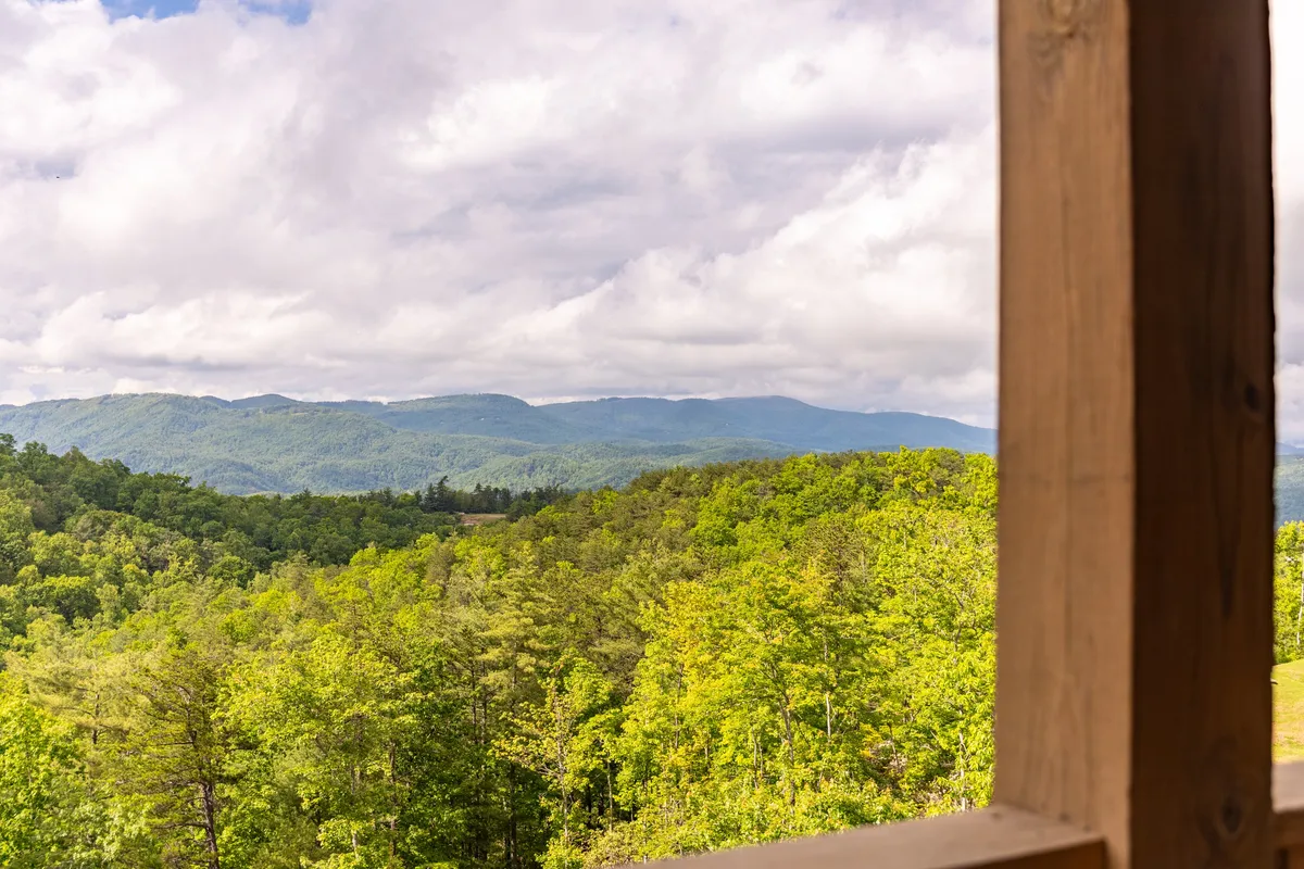 A breathtaking wide-angle view of the Blue Ridge Mountains, with rolling greenery and a dramatic sky. The scene showcases the natural beauty and adventure opportunities surrounding Calico Haven and the Blue Ridge Mountain Club.